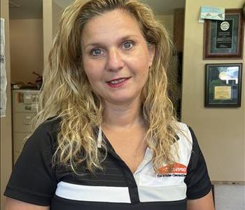 Long Blond hair Caucasian Female with Blue eyes, wearing black and white Servpro logo shirt